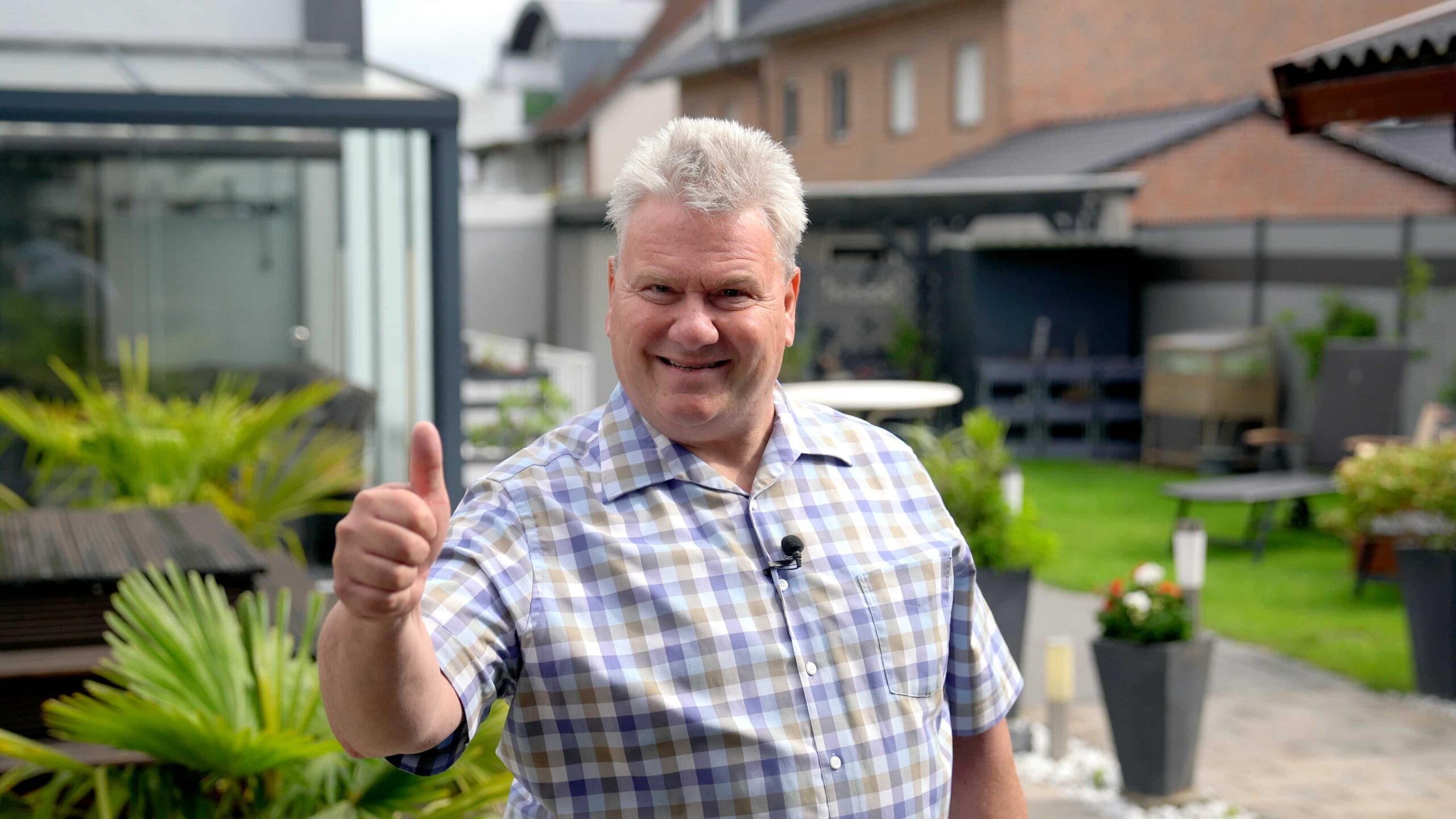 Lächelnder Mann gibt Daumen hoch im Garten