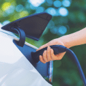 Person lädt Elektroauto an Ladestation