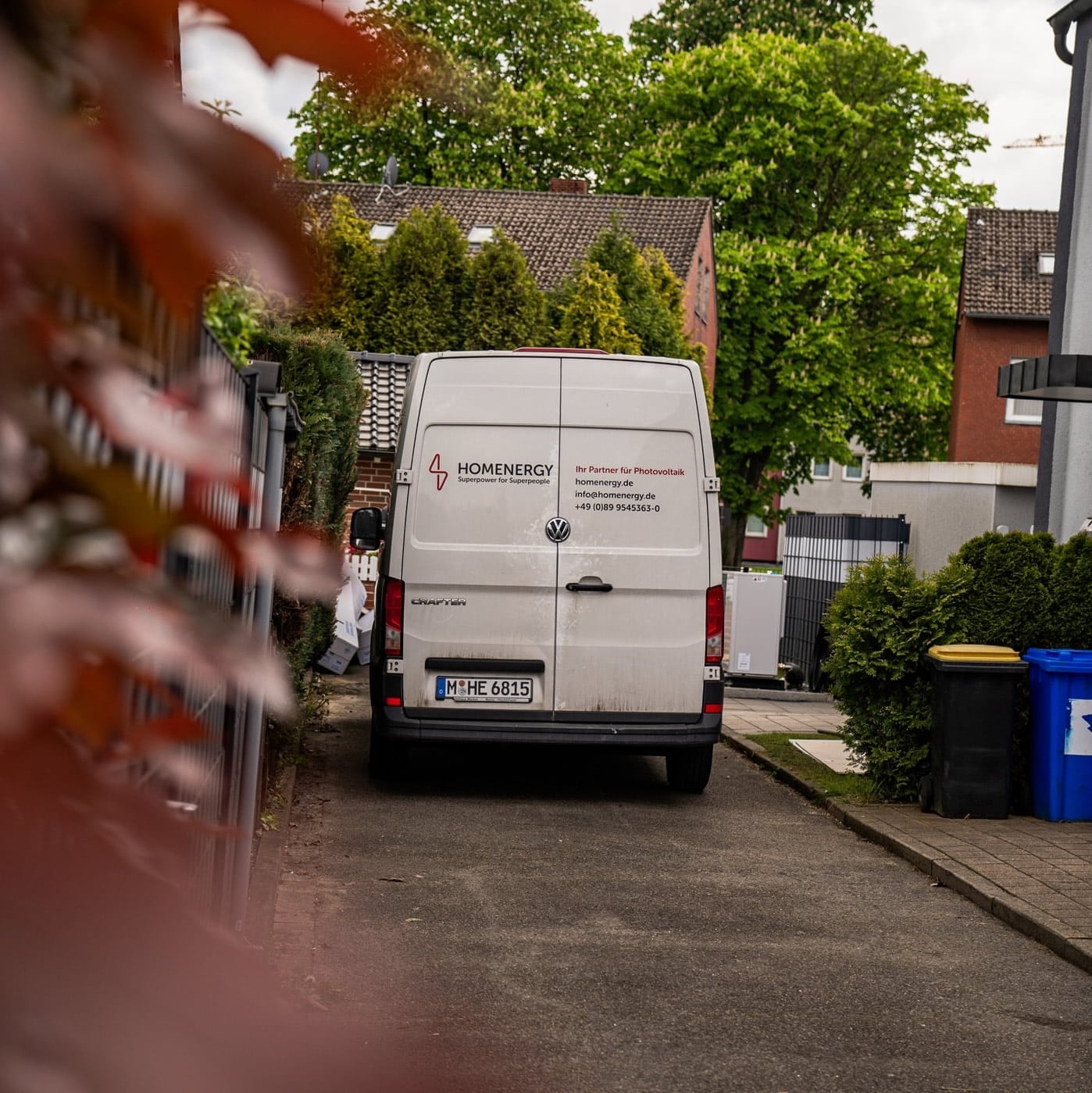 Lieferwagen auf enger Straße, umgeben von Bäumen